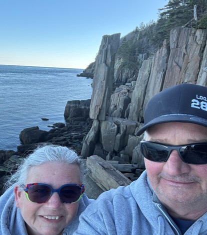 V travellers taking a selfie near coastal cliffs during a road trip.